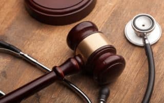 Brown and gold gavel and stethoscope on table